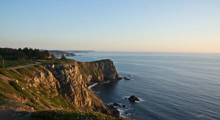 Naklejka premium A serene coastal landscape at sunrise, featuring rugged cliffs covered in vegetation meeting the calm, deep-blue ocean under a clear sky with a soft golden glow.