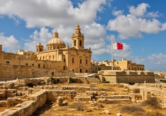 Fototapeta premium Historic maltese cathedral and ancient ruins under a cloudy blue sky