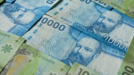 Closeup of chilean 10000 peso banknotes featuring a portrait with banco central de chile text