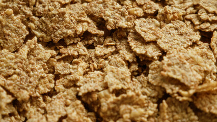 Closeup shot of corn flakes displaying a heap of crisp golden cereal flakes suggesting a delicious breakfast option