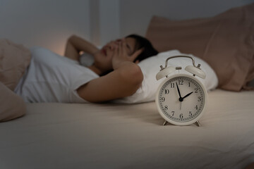 asian woman in bed late trying to sleep suffering insomnia, sleepless or scared in a nightmare,...
