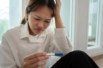Naklejka premium Depression and mental illness. Asian woman stressed from premarital pregnancy. Stressed girl confused with unhappy problems, arguing with boyfriend, single mother, social problems, disappointed