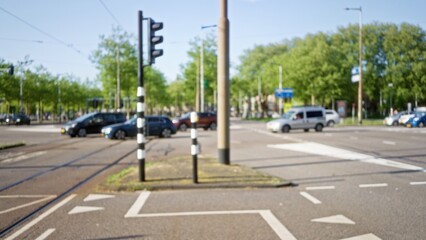 Blurred view of a busy european intersection with moving cars and clear sky, showcasing urban life, traffic signal, and green trees defining the vibrant cityscape.