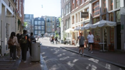 Blurred city street in amsterdam with people walking in the foreground, showcasing a vibrant urban scene with colorful buildings and a bustling atmosphere, out of focus.
