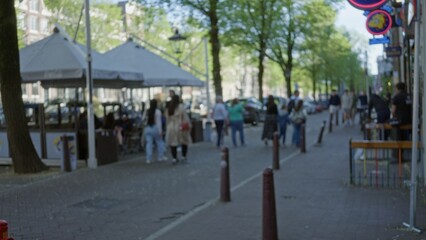 Outdoor scene featuring blurred people walking in a european city street with bright bokeh lights...