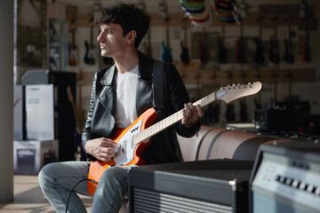 A man plays electric guitar in a music store