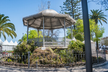 Old cast iron bandstand of 19th century romantic architecture with surrounding lake in the garden,...