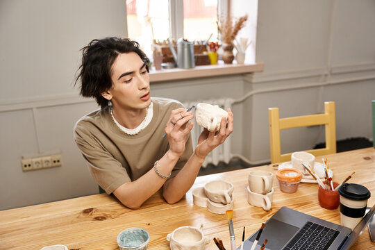 Handsome stylish man expressing creativity in pottery studio while crafting unique ceramics