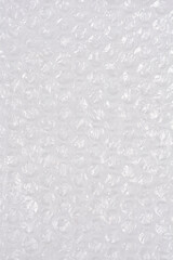 A high-angle, full-frame shot captures the textured surface of clear bubble wrap, showcasing its protective, translucent qualities as a packaging material
