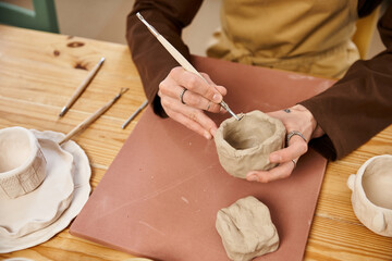 Stylish man engages in pottery art creating unique ceramics in a vibrant studio space