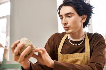Handsome stylish man creating pottery in a bright and creative studio space