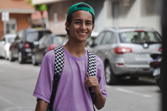 Teenage student boy with backpack and books on the street. Back-to-school concept