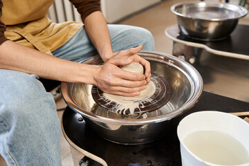 Creative man shaping clay in pottery studio during inspiring artistic session