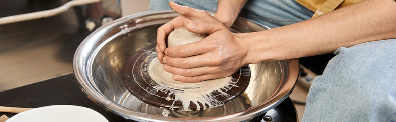 Handsome stylish man creating pottery in a creative studio filled with artistic materials