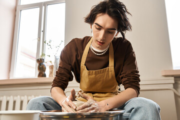 Handsome stylish man creating unique pottery pieces in a bright ceramics studio