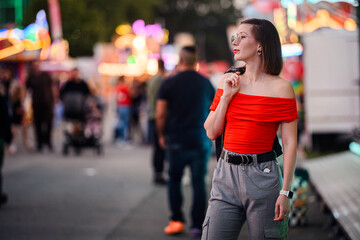 Stylish Woman at Night Carnival Under Colorful Lights