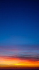 Fototapeta premium Vibrant sunset sky with fiery orange and yellow hues against deep blue