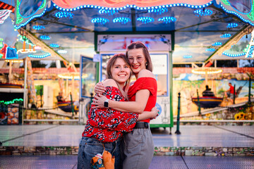 Obraz premium Happy Friends Hugging at a Colorful Amusement Park Ride