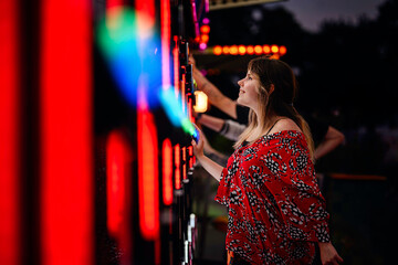 Focused Woman Playing Light Game at Night Carnival