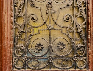 Window decorated with blacksmith's ironwork, rusty texture.
