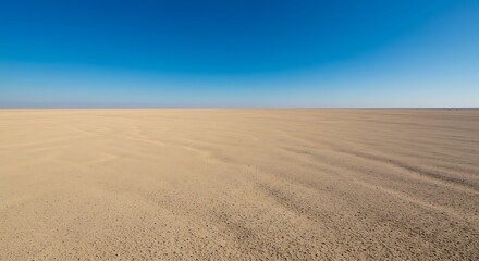 Fototapeta premium A vast and desolate desert landscape stretches endlessly under a brilliant, clear blue sky, showcasing the stark and untouched beauty of an arid wilderness.