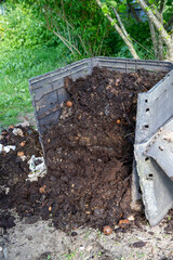 Ouverture d'un bac à compost de jardin extérieur rempli de déchets alimentaires et de déchets...