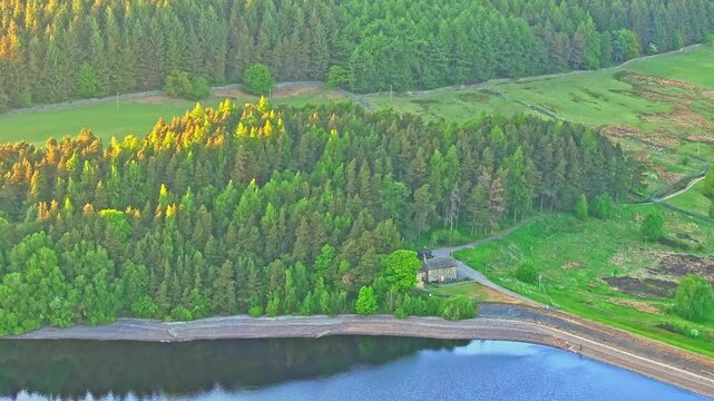 Aerial: Strines Reservoir, water storage reservoir, with forest during the day near Sheffield, South Yorkshire, England, crane up drone shot