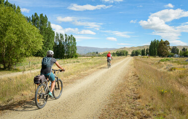 Two cyclists riding on Otago Central Rail Trail. South Island. New Zealand.