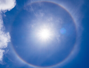 A beautiful rare atmospheric phenomenon of halo in the blue day sky.A halo is an optical phenomenon, a luminous ring around the Sun.