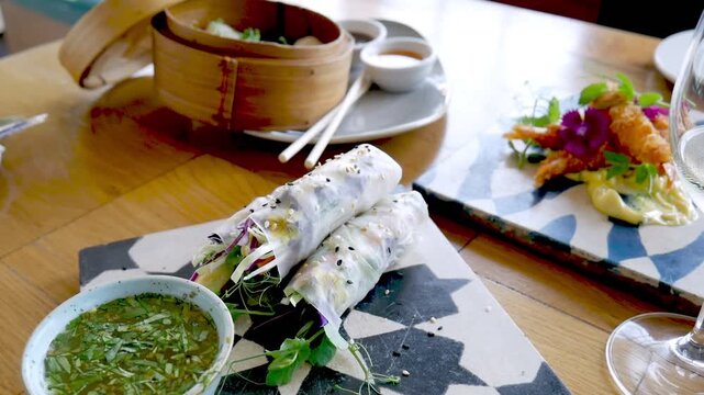Closeup of fresh Vietnamese rice paper rolls on plate next to dipping sauce