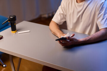 Cleaning a smartphone screen with a tissue needs attention for optimal hygiene and care