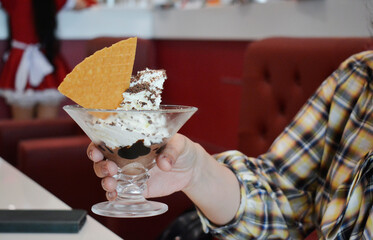People are eating ice cream and snacks in a shop.