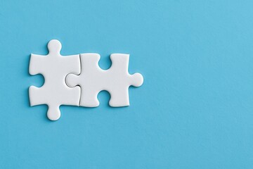 Two Interlocking White Puzzle Pieces on a Solid Blue Background Symbolizing Collaboration, Problem Solving, and Creativity in Business or Education Contexts