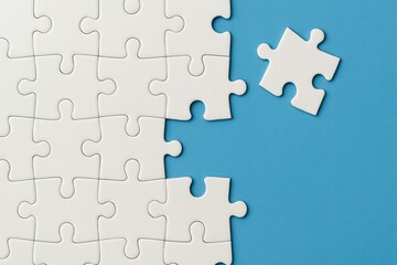 Fototapeta premium White Puzzle Pieces on Blue Background with One Piece Missing and Right Next to the Puzzle Showing Completion and Creativity Concepts