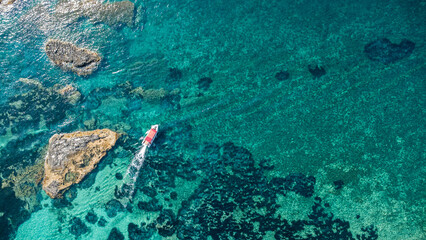 Red-Roof Boat, Coral Reef, and Rocky Outcrop – Aerial View of Mediterranean Coastline in...