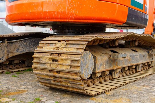 A close-up shot of heavy construction equipment tracks. Ideal for illustrating construction and engineering, this image conveys power, durability, and reliability in industrial projects.