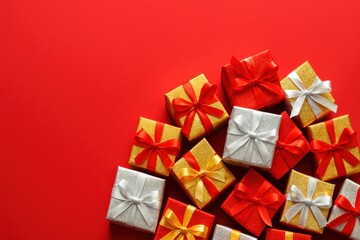 Colorful Gift Boxes with Ribbons Arranged on Bright Red Background for Celebrations and Special Occasions