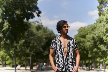 Young stylish man enjoying sunny day in park