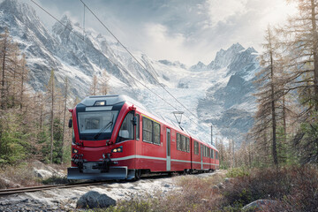 Fototapeta premium Red electric train navigating through snow-capped mountains and glacier under a serene sky