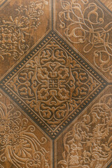 Intricate design of embossed tile showcasing ornate patterns in rich brown tones