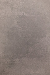 Wet spot on concrete surface exhibits irregular shape and texture in urban environment during late afternoon