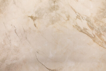 Polished marble surface showcasing beige and cream tones with subtle veins and patterns