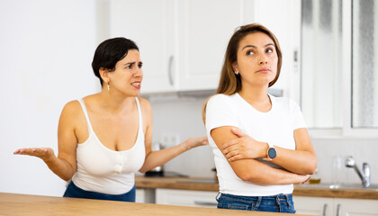 Offended frustrated young latin american woman listening to angry and dissatisfied girlfriend,...