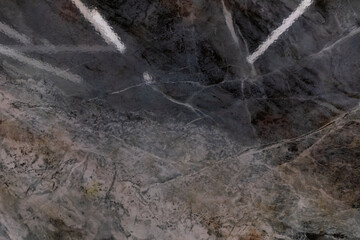 Unique stone surface with intricate patterns reflecting light in a natural setting during daytime