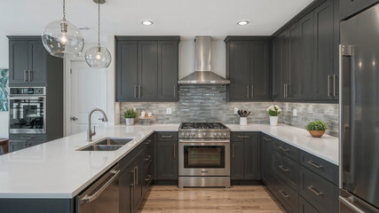 Modern gray kitchen boasting stainless steel appliances and glass pendant lights