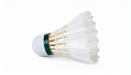 A white shuttlecock with a green band and delicately arranged feathers rests against a soft surface—evoking motion, sport elegance, and the graceful dynamics of badminton.