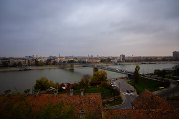 Obraz premium Autumn aerial view of the Danube River and Varadin Bridge from the Petrovaradin side, overlooking Novi Sad, Serbia, on an overcast fall day