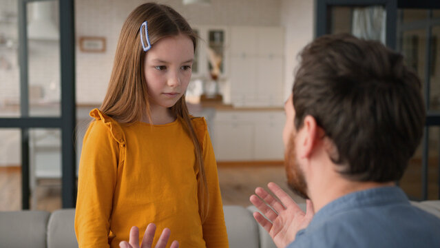 Stressed annoyed Caucasian dad male father man shout at upset daughter in fault kid at home conflict guy discipline little child family difficulty parent arguing schoolgirl girl bad behavior trouble