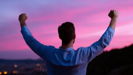 A Man's Victory Under the Sky: Capturing a silhouette of a man exuding triumph with raised arms against a captivating gradient sky at sunset.