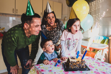 Family celebrating birthday with cake and balloons